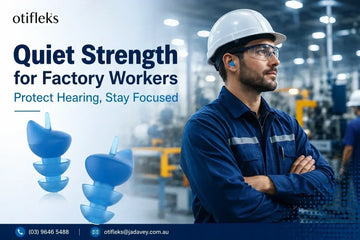 Worker wearing noise-reducing earplugs in a busy factory environment